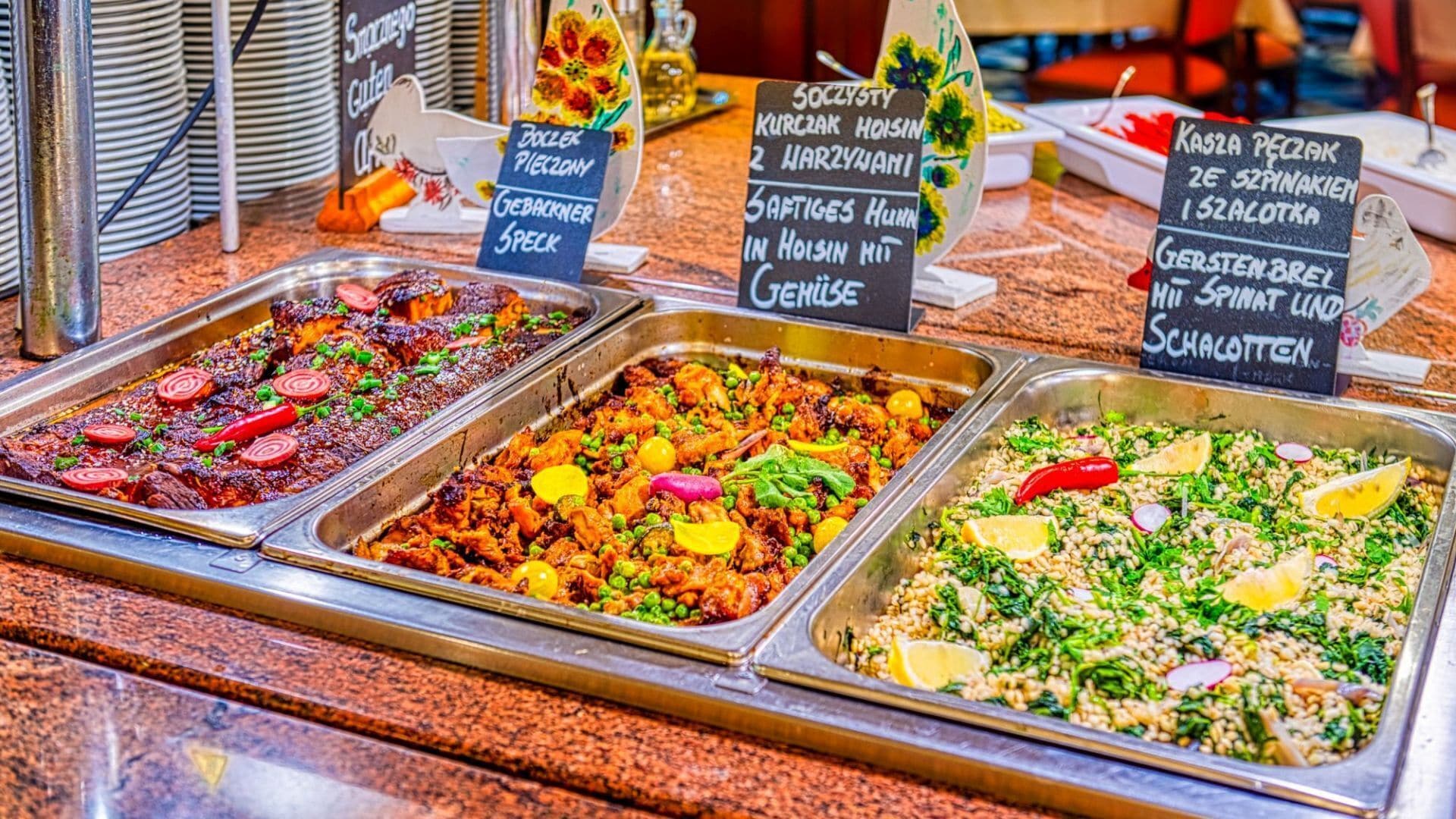 A buffet with various dishes including meat, vegetables, and salads.