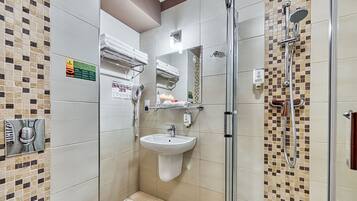 A modern bathroom with a glass-enclosed shower, a sink, and a towel rack.