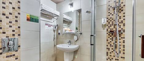 A modern bathroom with a glass-enclosed shower, a sink, and a towel rack.