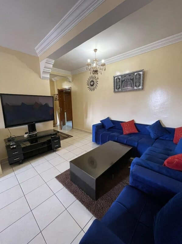 Relax in this stylish living room with a large flat-screen TV, comfortable sofa, and a coffee table.
