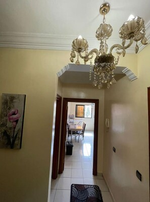Stunning hallway leads to a dining area with a beautifully set table and a window view.