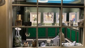Une boutique offrant une vue imprenable sur le ciel grâce à une grande fenêtre, agrémentée d’un lustre et présentant divers articles en exposition.