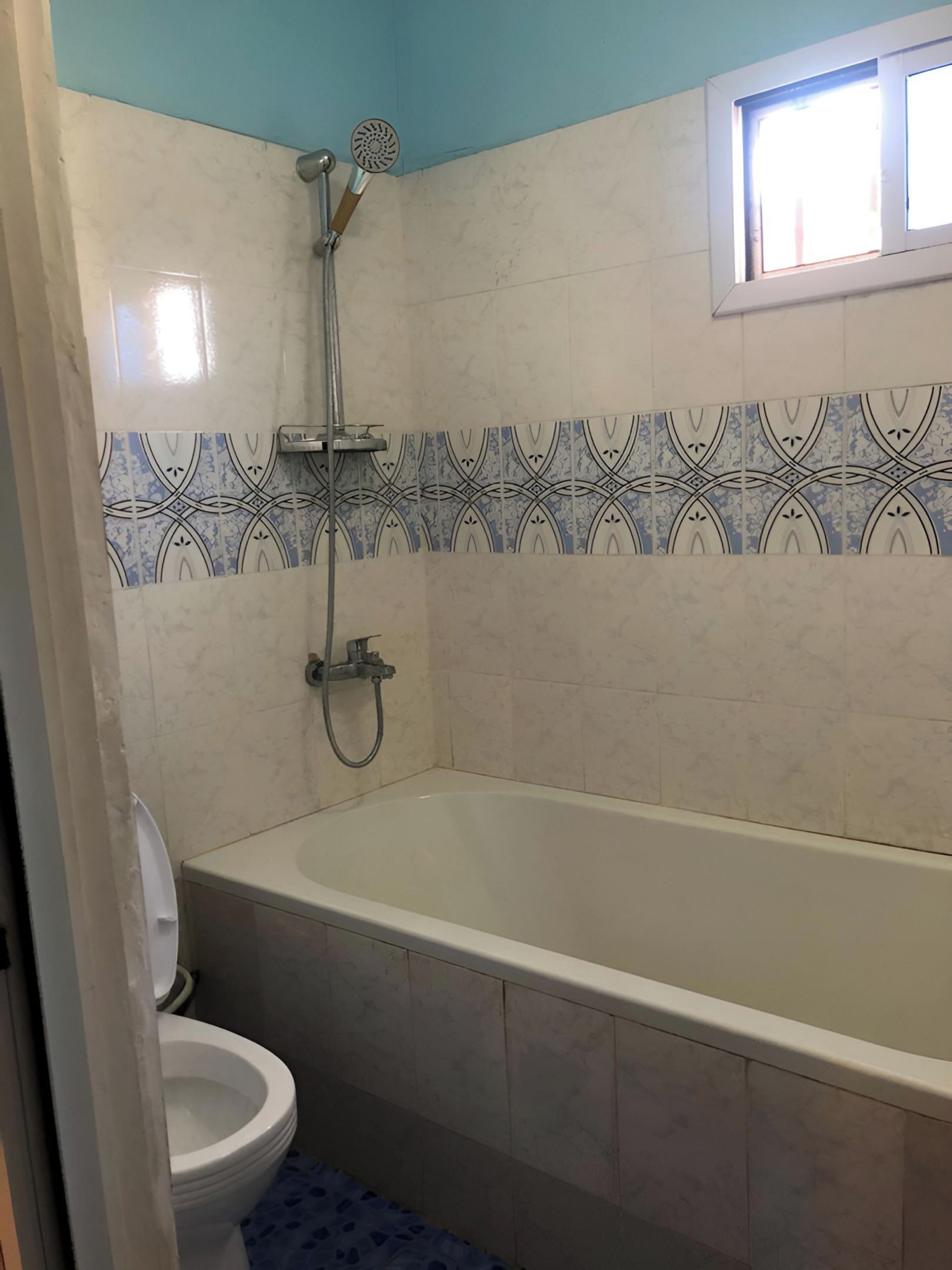 A bathroom with a bathtub, toilet, and shower.