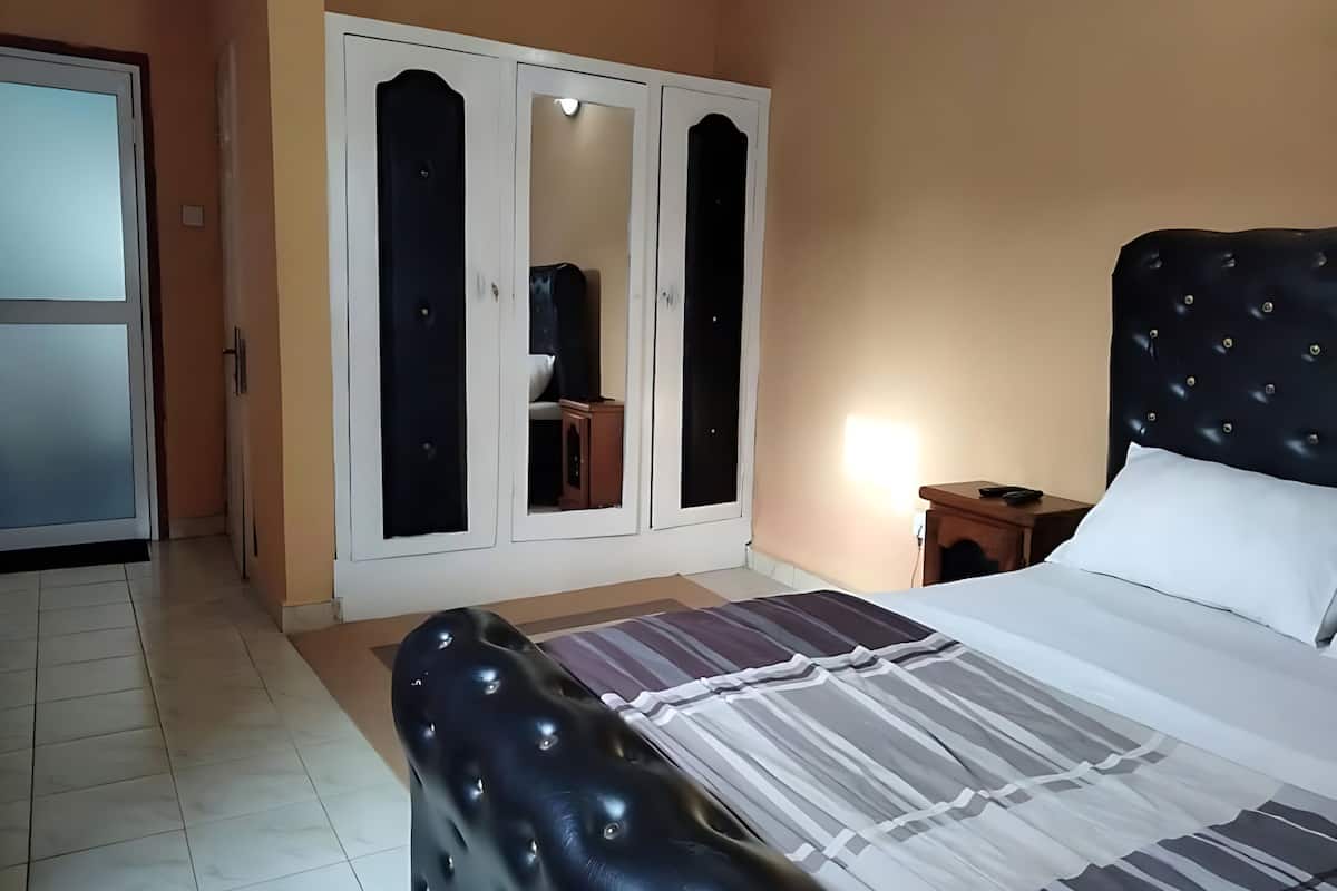 Une chambre à coucher avec un lit, une armoire et une table de chevet.