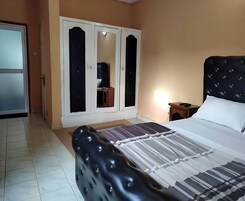 Un dormitorio con cama, armario y mesita de noche.