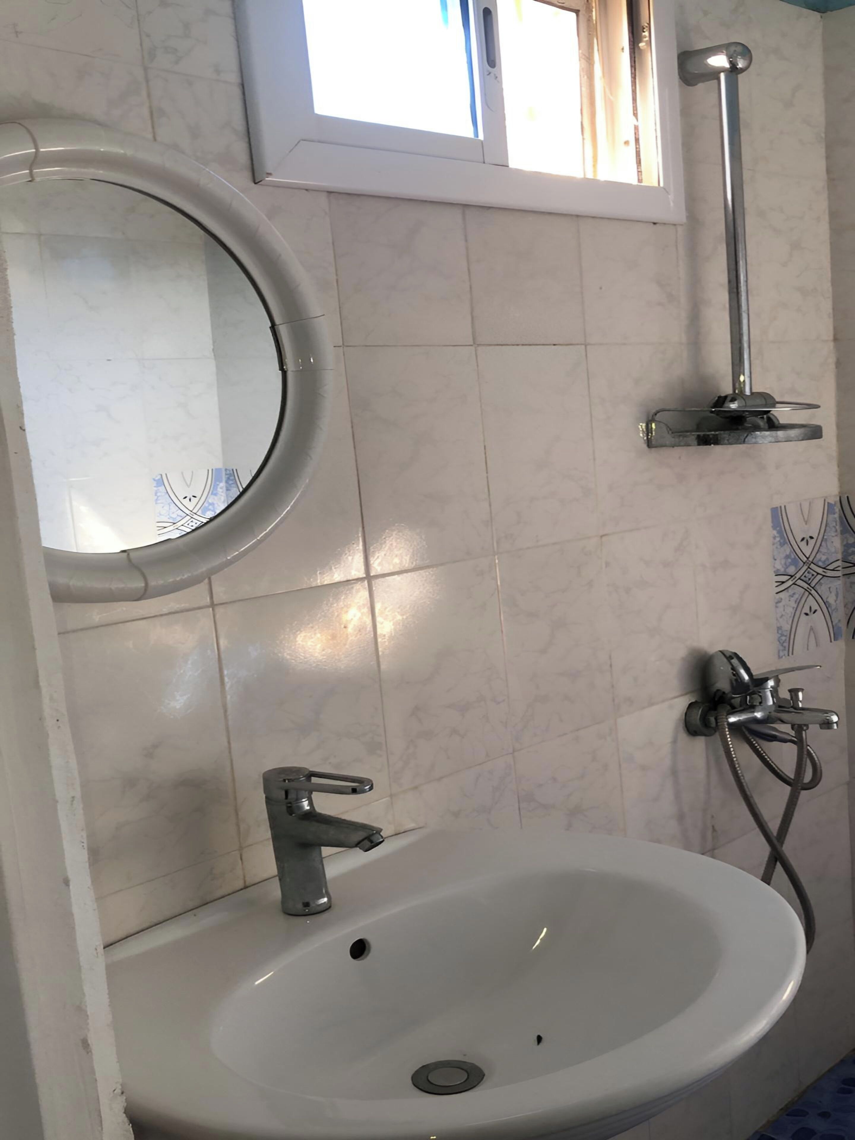 Une salle de bain avec un lavabo, un miroir et une douche.