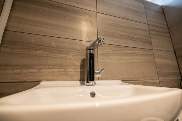 A bathroom sink with a modern faucet and a mirror above it.
