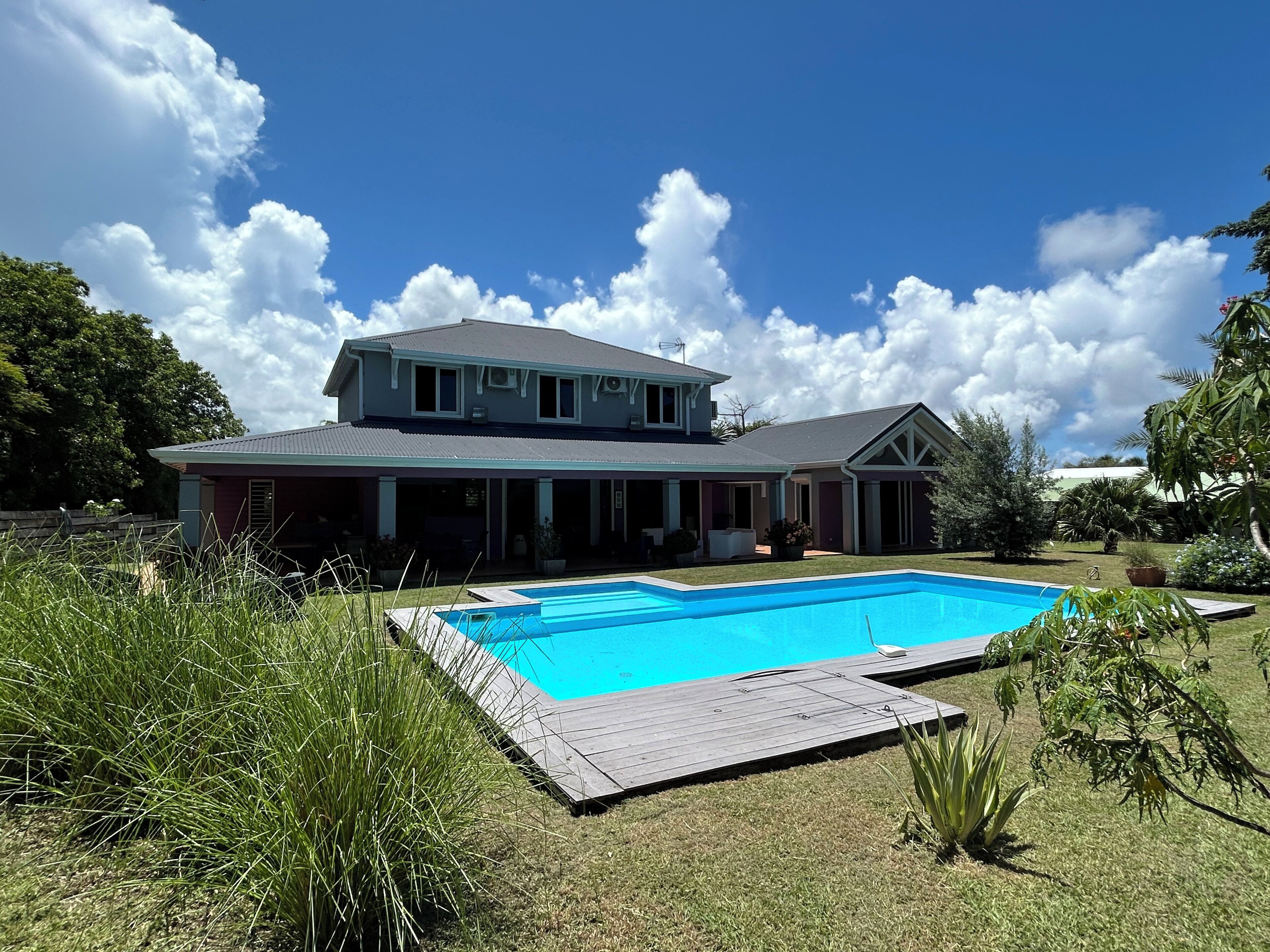 Une maison à deux étages avec une piscine dans le jardin.