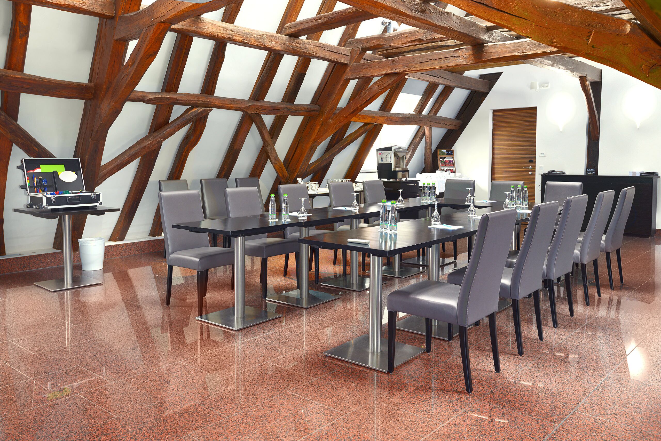 A conference room with a long table, chairs, and a presentation screen.