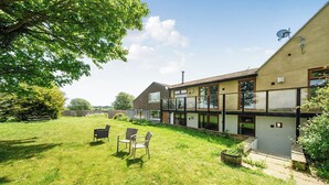 A modern house with a large glass extension, a grassy backyard, and a satellite dish. - Relaxing Room With Ensuite Rutland Point (Oakham)