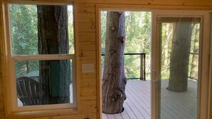 A wooden cabin with large windows and a deck. - Yeti's Tree House: Where Magic Happens (Portland)