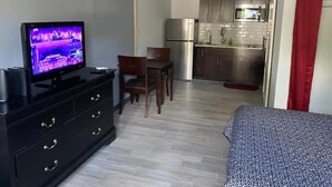 A compact hotel room with a TV, a small dining table, a kitchenette, and a bed. - Backyard Escape

 (Tampa)
