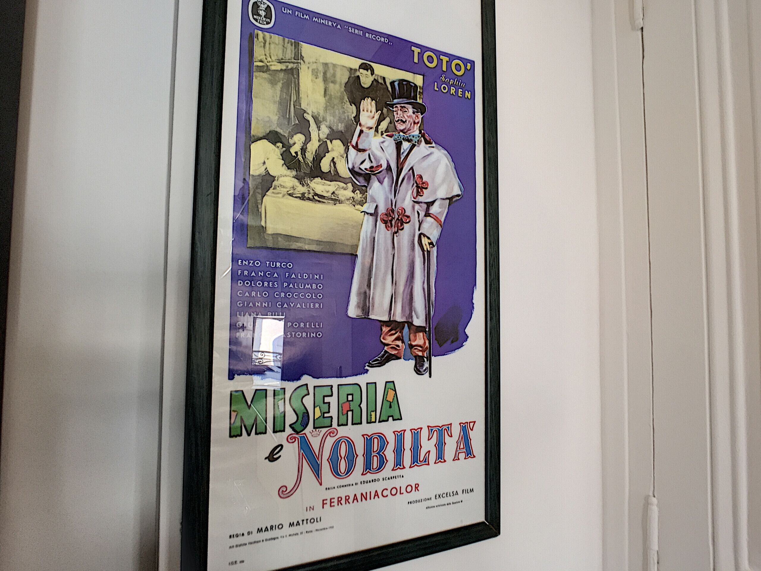 Un cartel enmarco de la película 'Miseria e Nobiltà', mostrando un personaje con bata blanca y bombín.