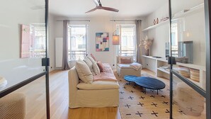 A modern living room with a sofa, coffee table, and a ceiling fan.
