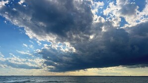 A beach with a view of the ocean and a cloudy sky. - The Upper Peninsula's Hidden Gem (Rapid River)