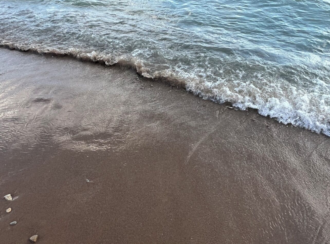 Une plage de sable fin aux vagues douces.