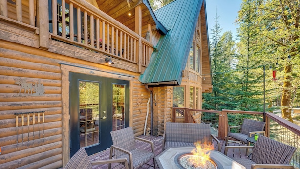 A log cabin with a deck featuring outdoor furniture and a fire pit. - Spacious Packwood Cabin w/ Hot Tub - Near River (Packwood)