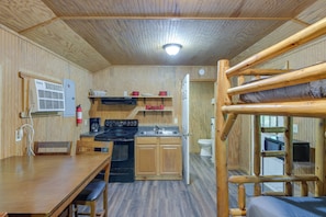Une cuisine de taille réduite, avec des meubles de rangement en bois, une cuisinière et un évier.