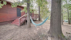 A rustic cabin with a wooden deck and a hammock between trees. - Fort Towson Cabin < 1 Block to Raymond Gary Lake (Fort Towson)