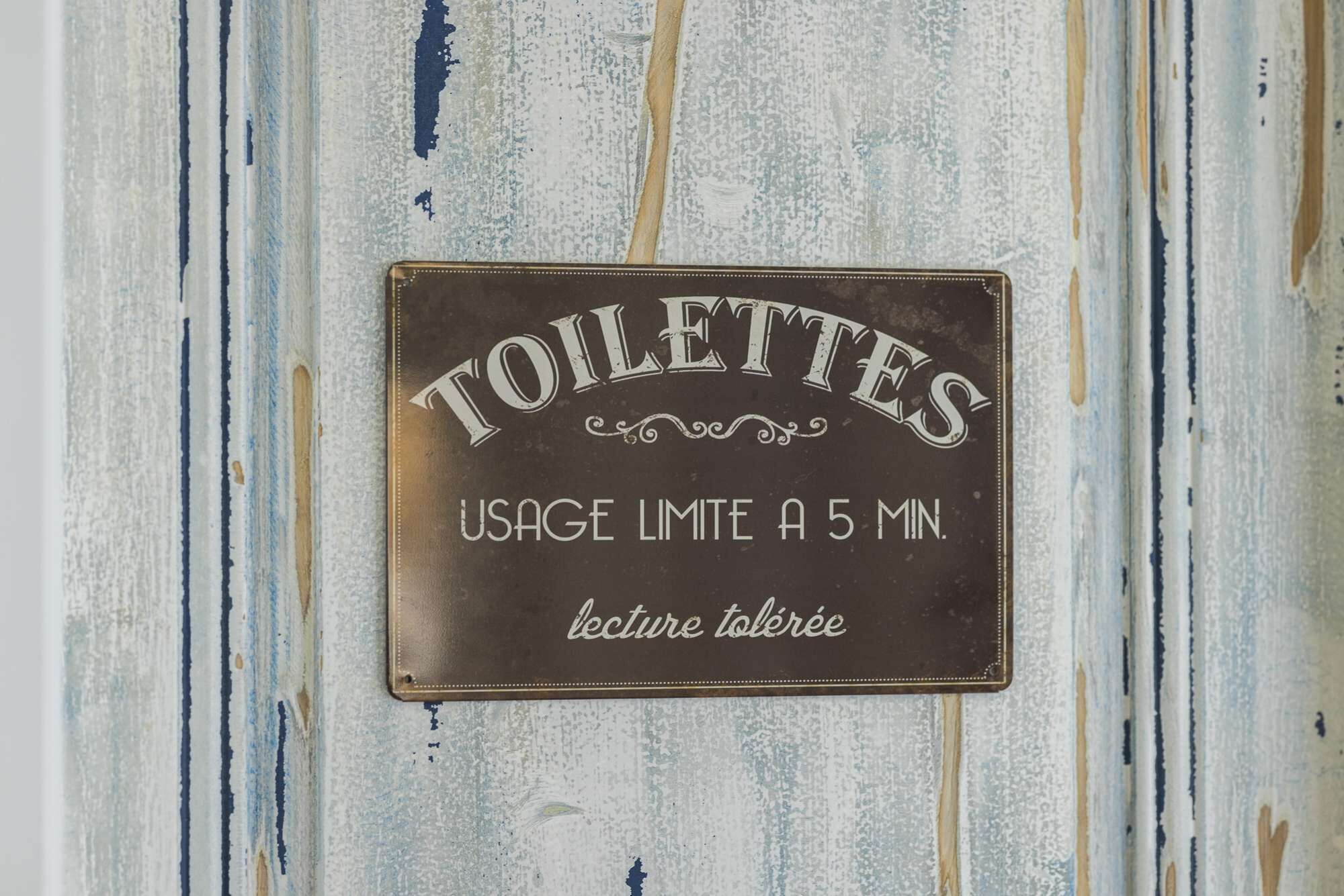 A sign with the word 'TOILETTES' and a usage limit of 5 minutes.