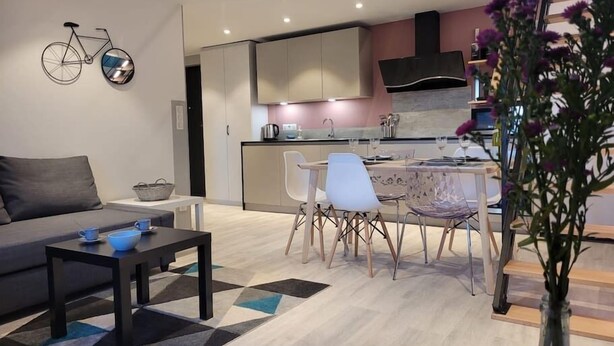 Un salon moderne avec un canapé, une table basse et un coin repas avec des chaises.