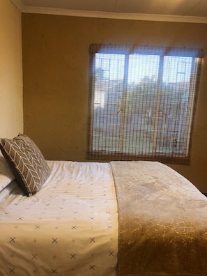 A room with a bed, a window with blinds, and a wall. - Inviting 3-bed Apartment in Edenvale (Edenvale)