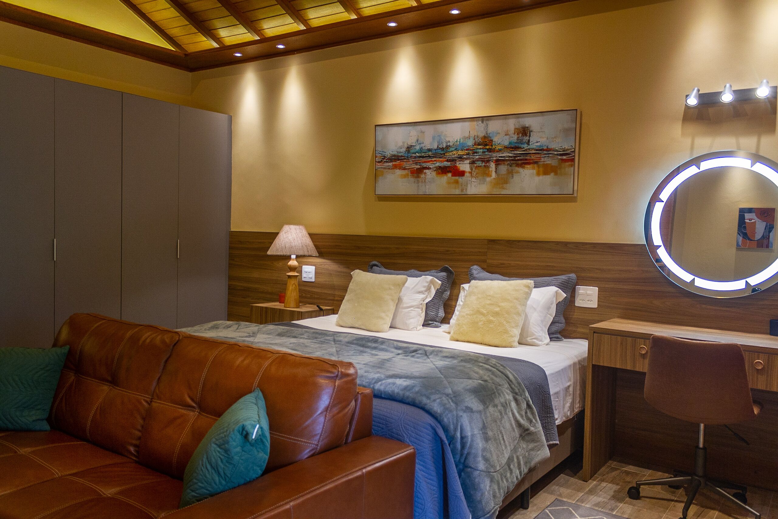 Ein Schlafzimmer mit Bett, Schreibtisch, Stuhl, Kleiderschrank und einem Bild an der Wand.