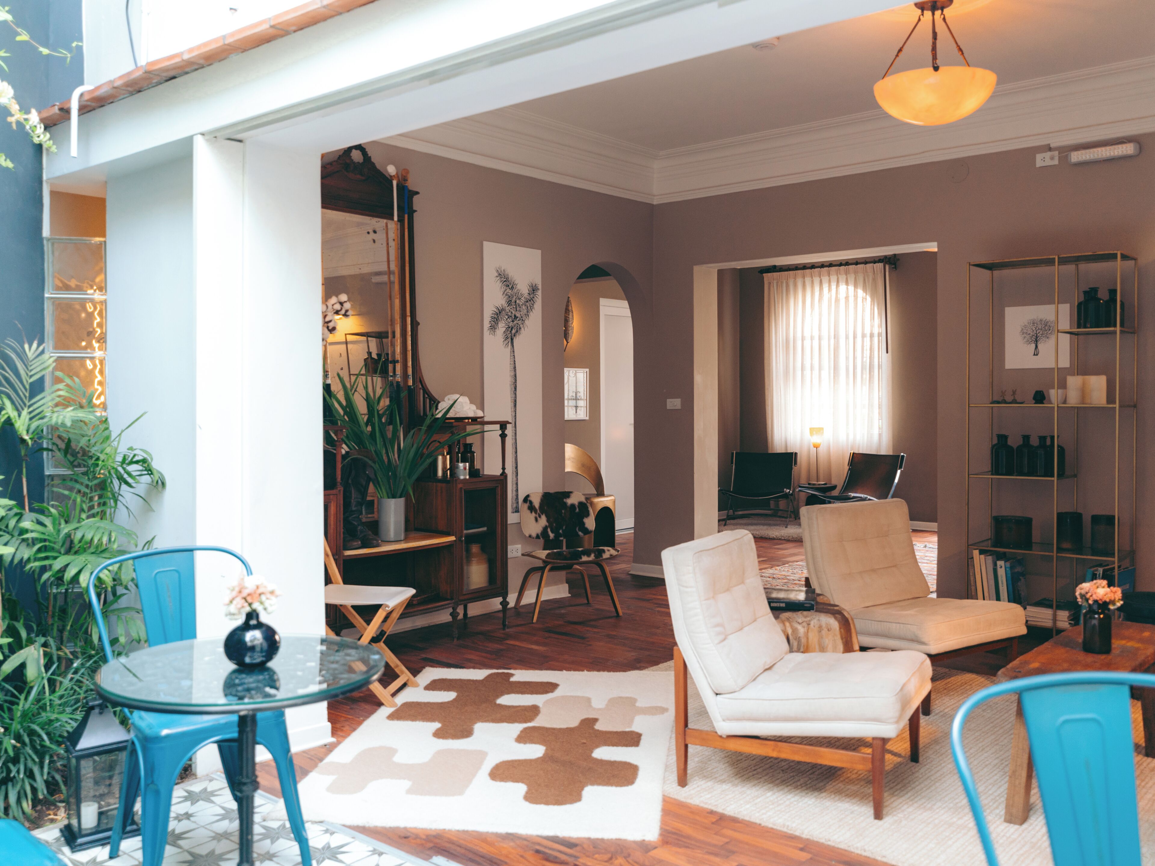 A spacious living area with a sofa, chairs, a coffee table, and a bookshelf.
