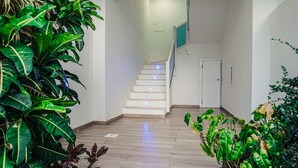 A staircase leading to a room with white walls and a wooden floor.