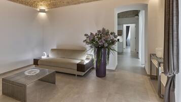 Um interior moderno com teto de pedra, um sofá, uma mesa de centro e um vaso de planta.