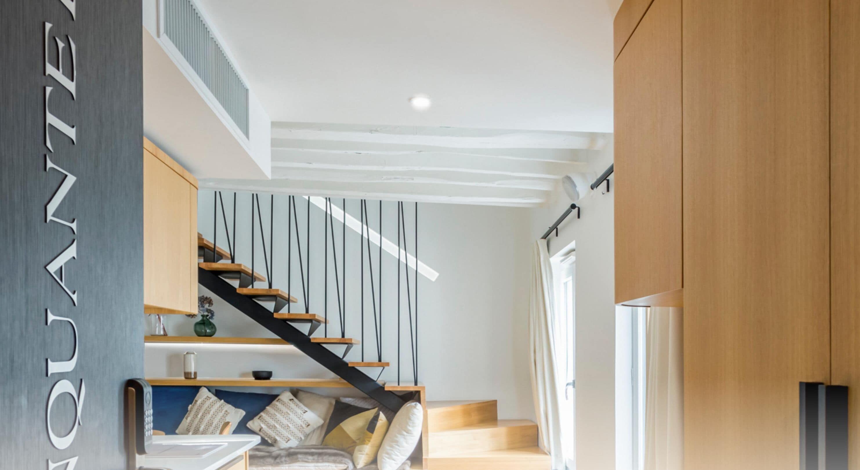 A modern interior with a staircase, wooden flooring, and a minimalist design.