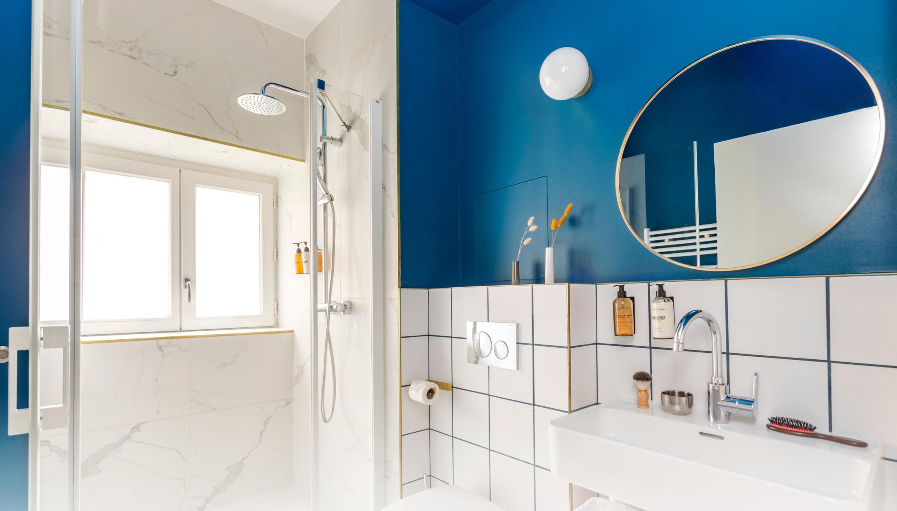 Une salle de bain moderne avec une douche, un lavabo et un miroir.