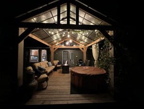 A cozy, rustic interior with a wooden deck, a fireplace, and a comfortable seating area. - Cozy Stone Cottage (Broken Arrow)