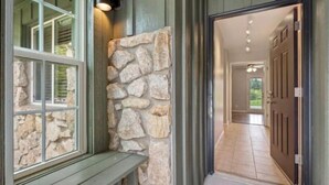 Un muro de piedra con un banco, una puerta y un pasillo que conduce a una habitación.