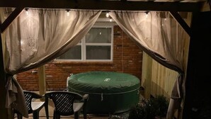 Un patio coperto con un tappeto elastico verde, un tavolo e sedie.