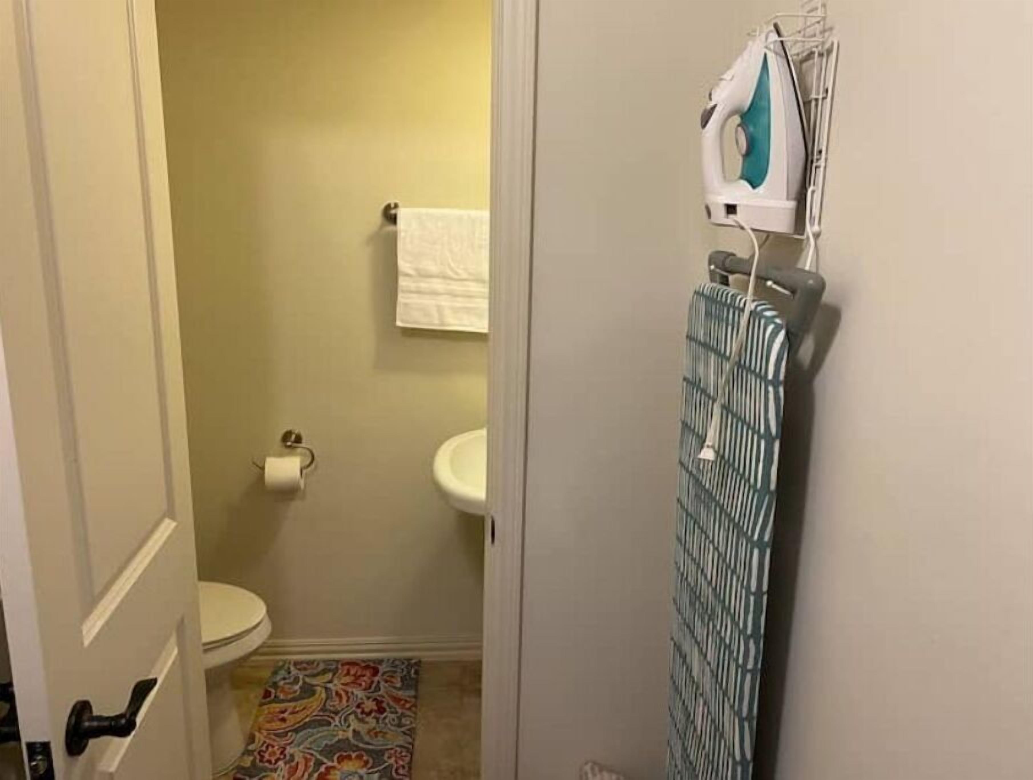 Een badkamer met toilet, wastafel en een handdoek aan de muur.