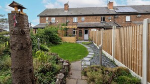 A residential property with a brick house, a garden with a stone pathway, and a wooden fence. - 3 Bed 1.5 Bath | Canal Side Location | Close To Wakefield & Leeds | Pets Welcome (Stanley)