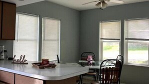A kitchen with a central island, a ceiling fan, and a view through the windows. - Indian Lake Cottage for Nature Lovers - Apt A

 (Dowagiac)