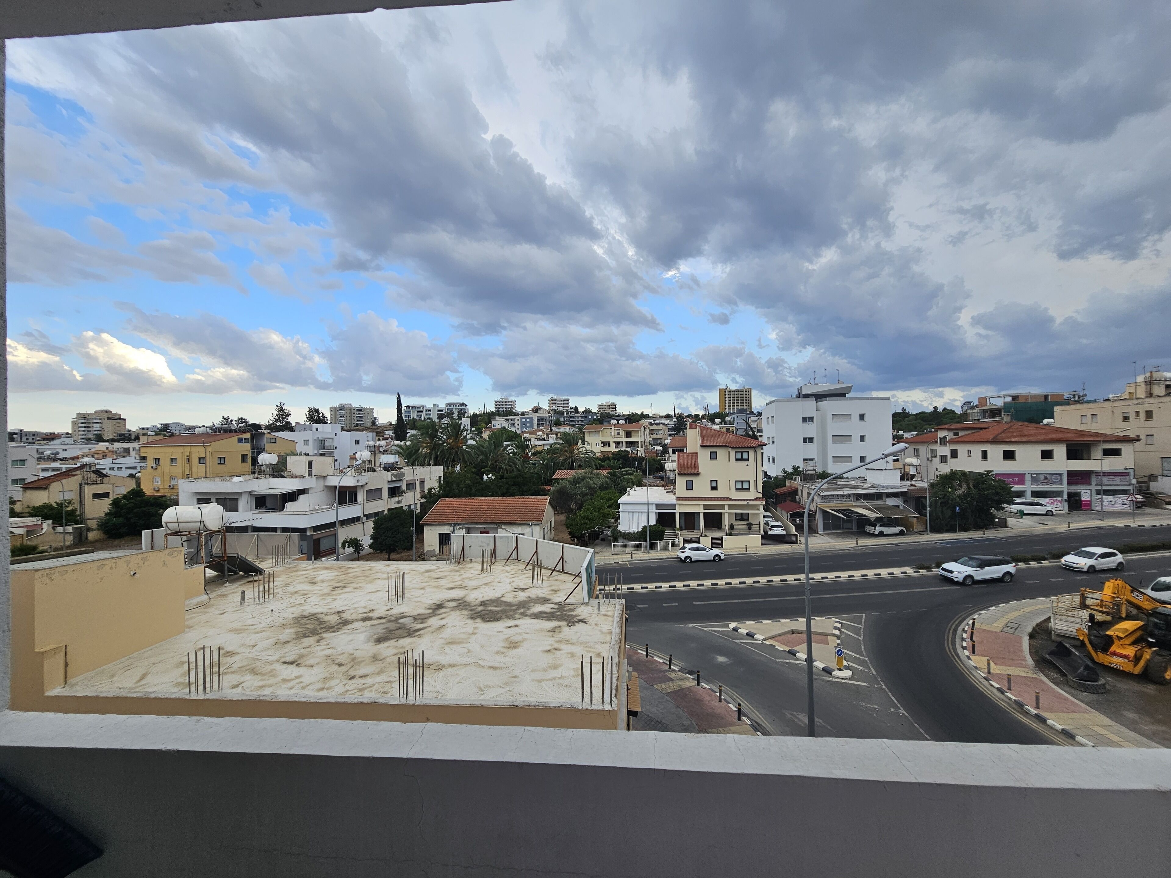 A cityscape with buildings, roads, and construction equipment.