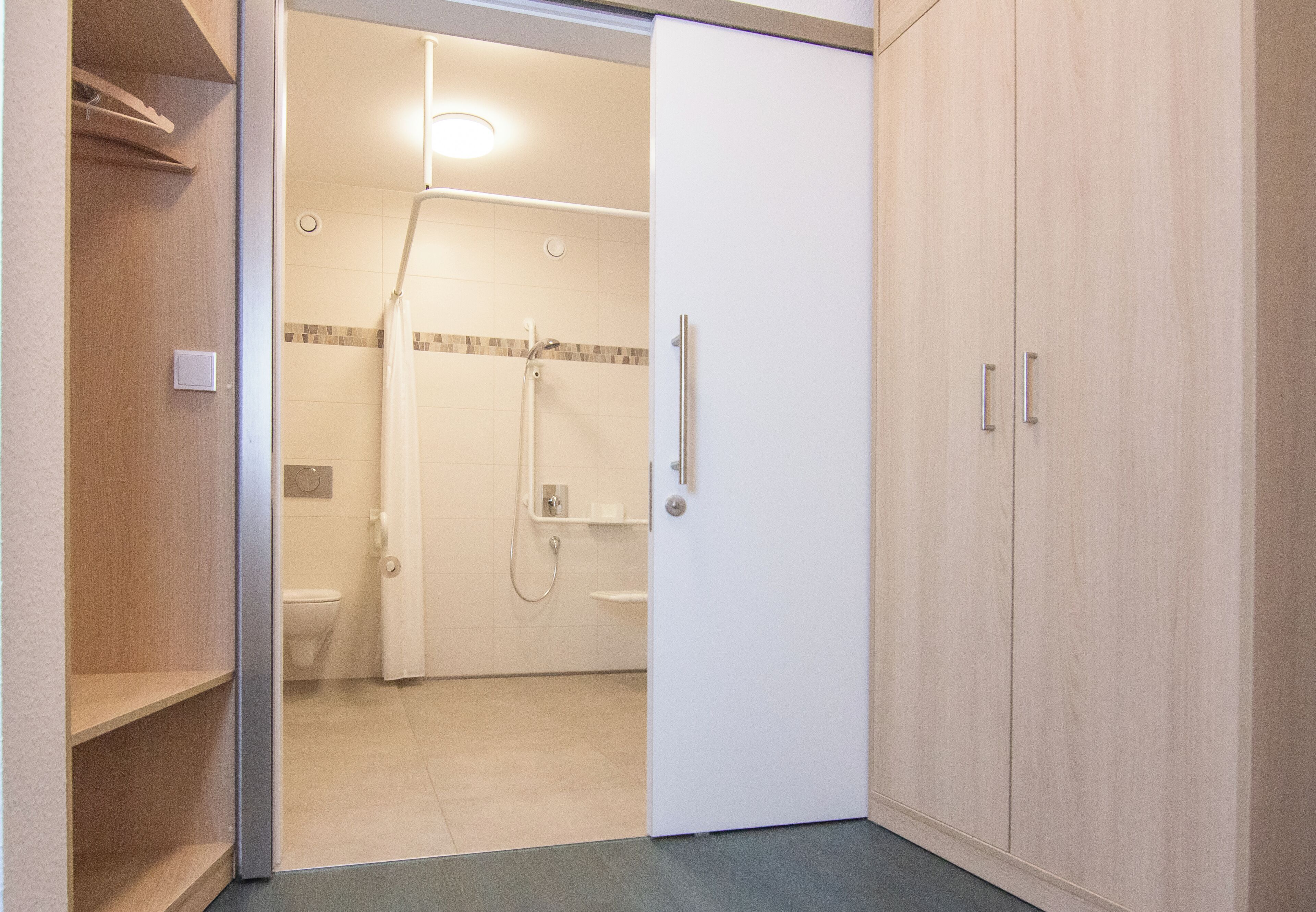 Un baño con ducha, inodoro y un armario.