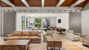 A spacious living area with leather sofas, wooden coffee tables, and a dining area with a table and chairs. - The Trailside Retreat | Ski on&off w/ Fireplace! (Dover)