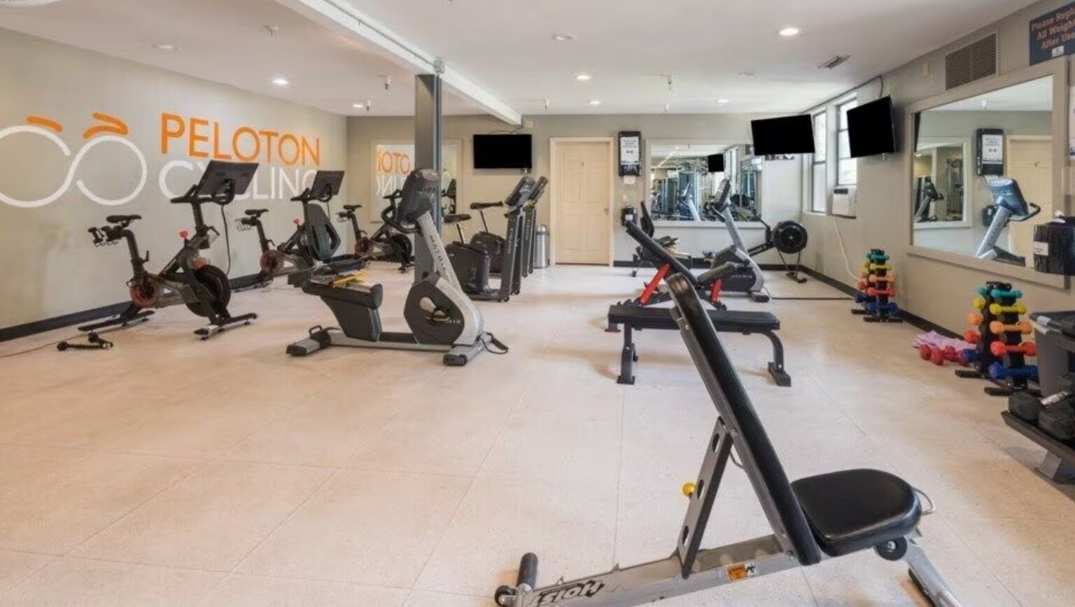 Une salle de sport équipée de divers appareils d’exercice, notamment des tapis de course et des vélos d’appartement.