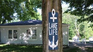 Puuhun on kiinnitetty kyltti, jossa lukee ”Lake Life” ja on kuva veneen ankkurista.