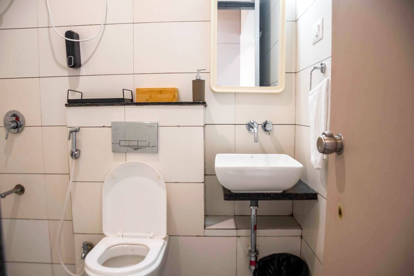 Un baño con inodoro, lavamanos y espejo.