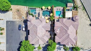 Vue aérienne d’un complexe hôtelier doté de plusieurs piscines, d’un parking et d’une plage.