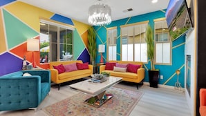 Un salon chaleureux et accueillant, avec deux canapés jaunes, un fauteuil bleu et un tapis à motifs.