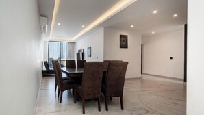 A modern dining area with a marble floor, a round table, and six chairs. - Modern apartment in the center near the beaches (Playa del Carmen)