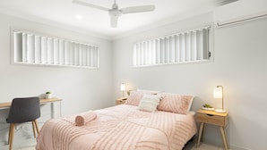 Una camera da letto con un letto, comodini, una scrivania e una sedia.