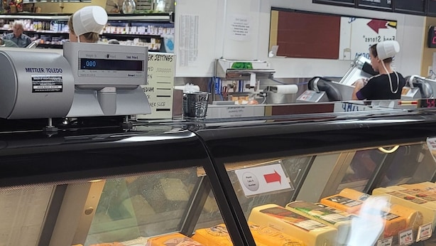 A deli counter with a variety of cheeses and deli meats on display.