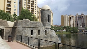 A stone structure with a dome and a cylindrical tower, surrounded by a water body and modern high-rise buildings in the background. - 3Bed/2Bath Condo in Gorgeous Orlando Resort Near Disney!! (Lake Buena Vista)